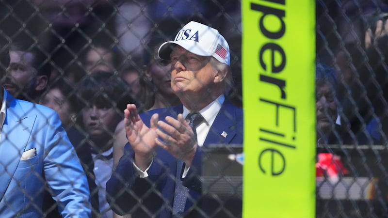 President Donald Trump applauds after Justin Gaethje defeated Ilia Toupruia in the lightweight...