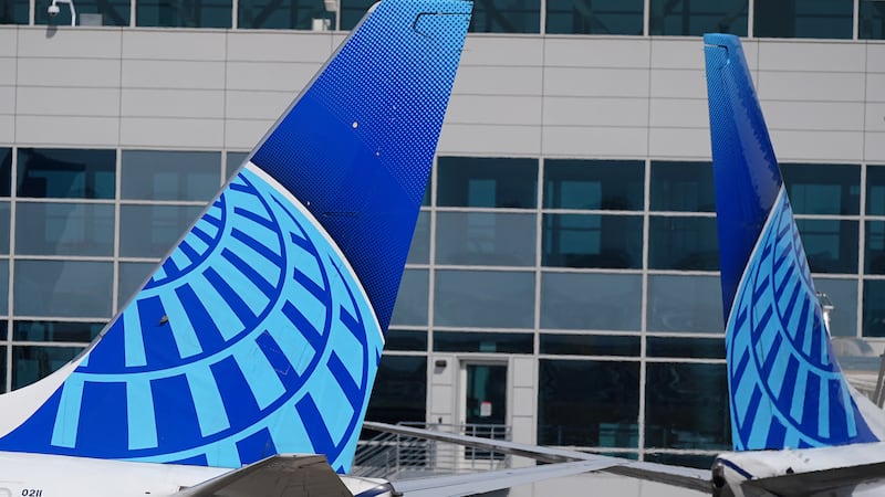 FILE - The company logo adorns the tail sections of United Airlines jetliners as they taxi to...
