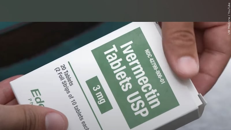 A person holds a box of ivermectin tablets.