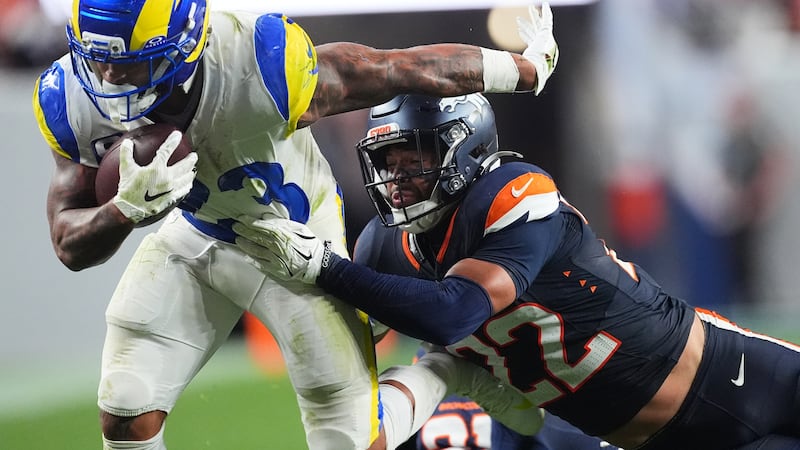 Los Angeles Rams running back Kyren Williams, left, is stopped by Denver Broncos safety...