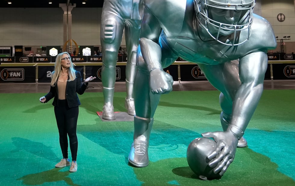 FILE - ESPN anchor Linda Cohn reports next to large images of football players at a fan fest...